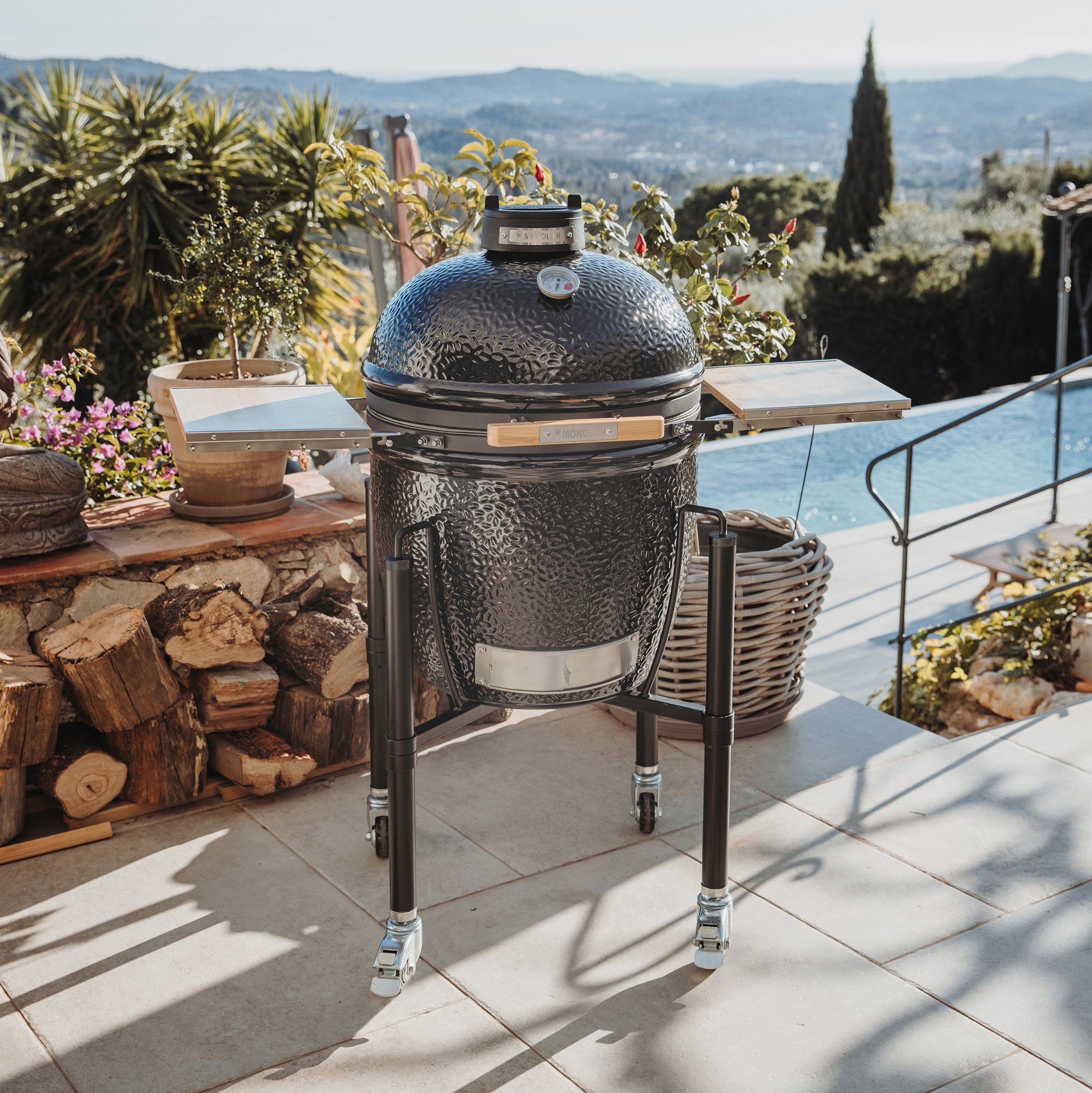 MONOLITH ONE.55 Keramikgrill mit Bambus-Seitentischen auf Terrasse mit Panoramaausblick – stilvoller Kamado-Grill für gehobenes Outdoor-Cooking.
